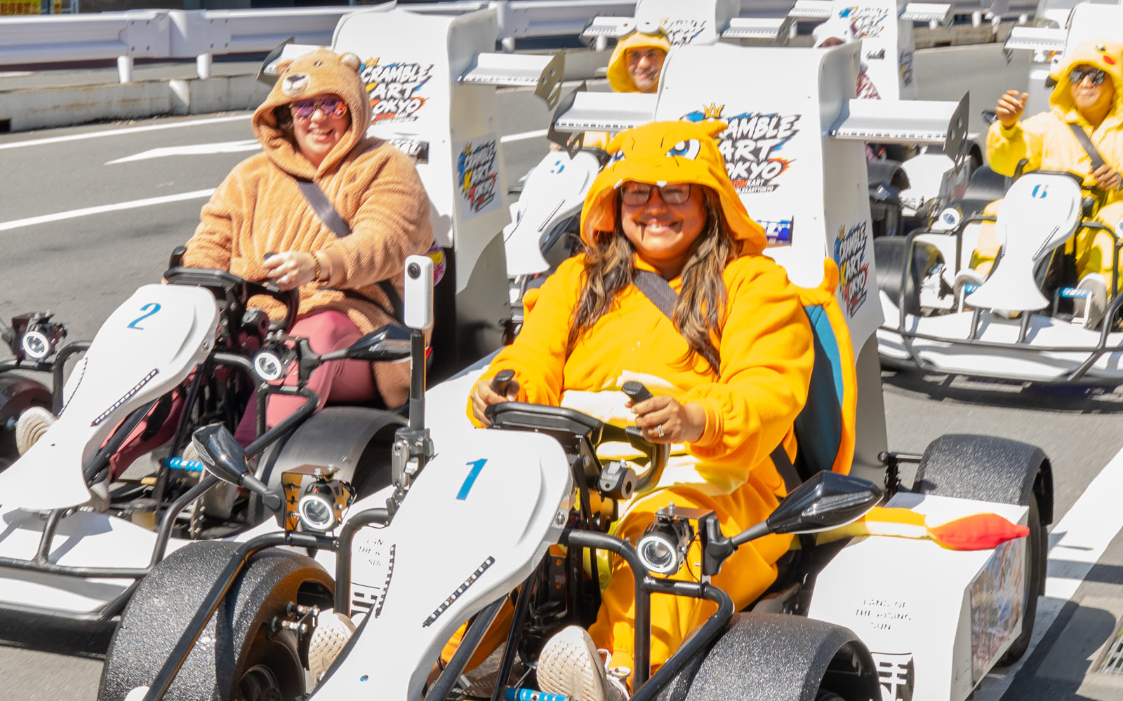 A guest in a character onesie driving a SCRAMBLE KART TOKYO go-kart on a Tokyo street